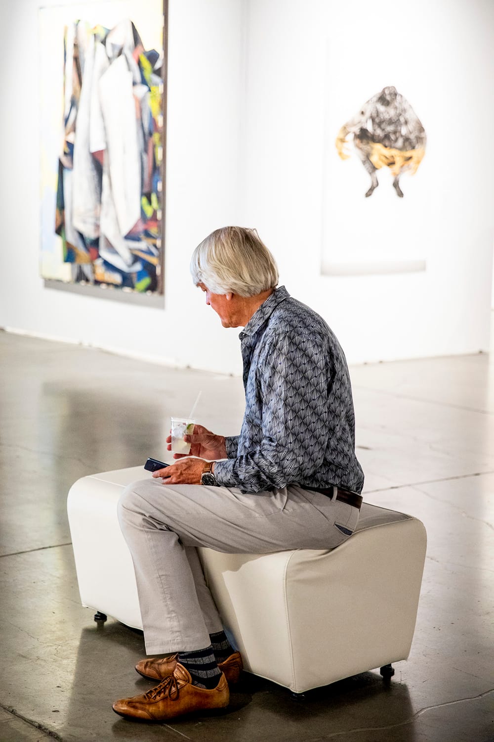 An attendee has a drink during the Seattle Art Fair at CenturyLink Field Event Center on Aug. 1, 2019.