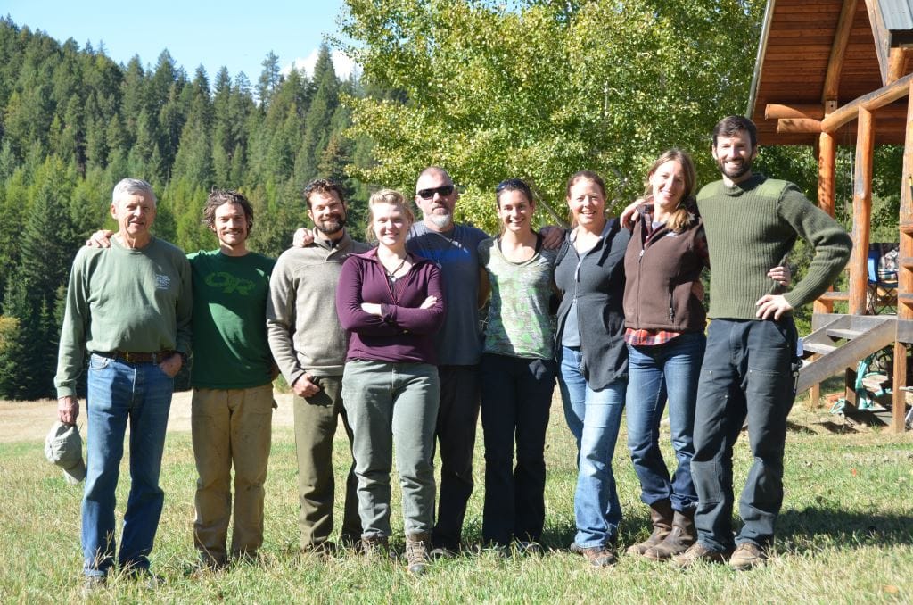 Group standing together for a photo outside cabin