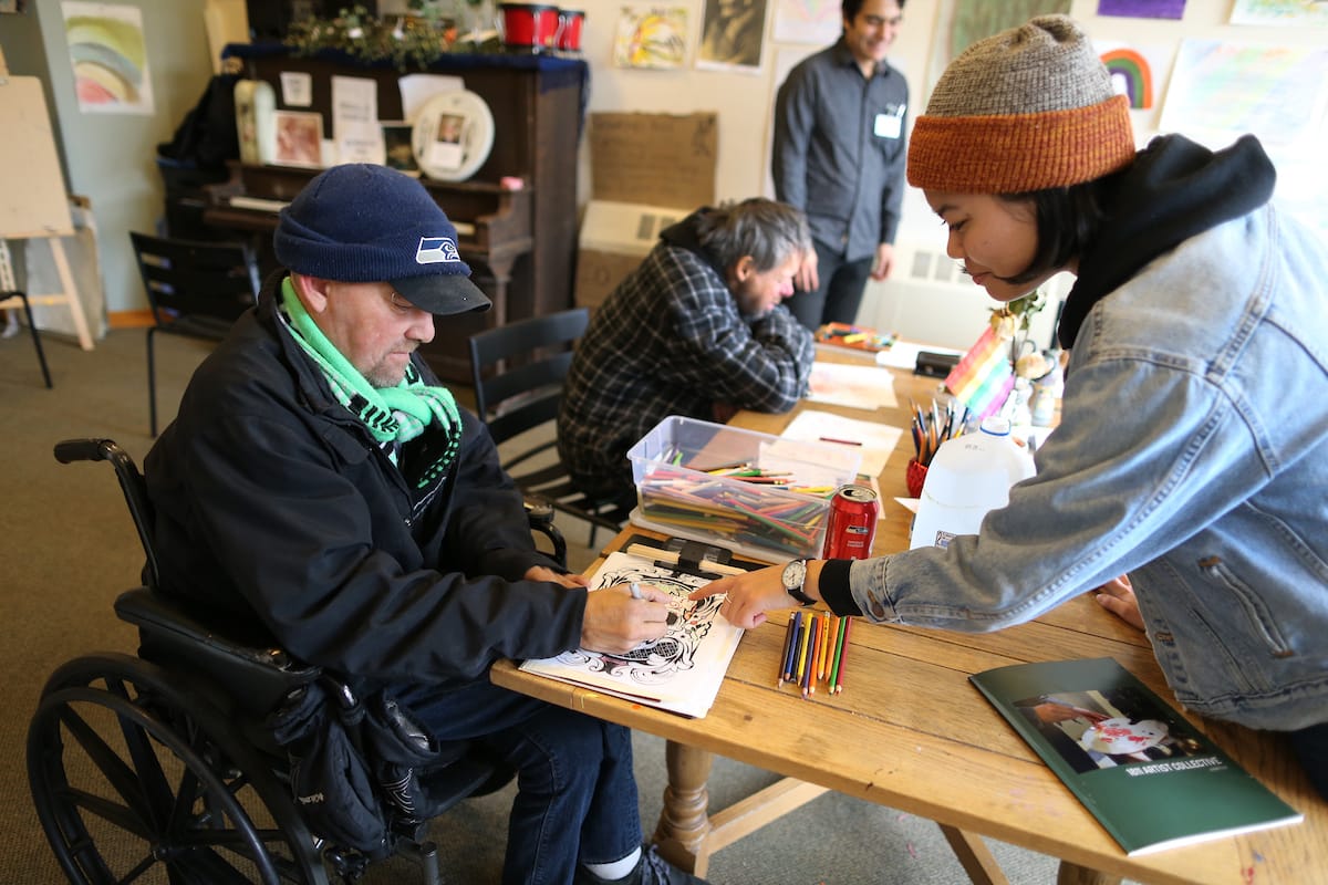 Brian Darchuck, an artist from Seattle whose work is featured in the current show, speaks with Alyssa Hatsukami, a research study coordinator from the UW School of Medicine. (© Karen Ducey)