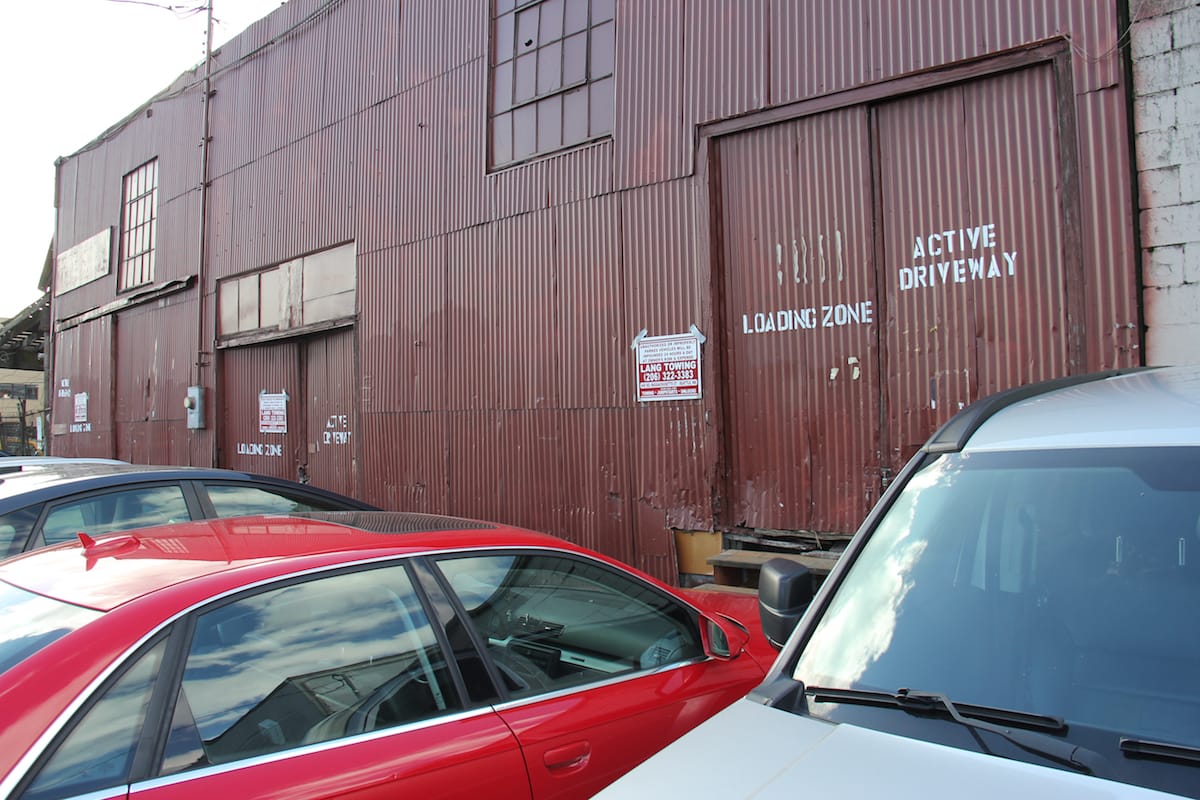 A business off Occidental Avenue in Seattle's SODO neighborhood tries unsuccessfully to ward off public parking in its adjacent right of way by posting tow warning signs with duct tape on a recent afternoon.