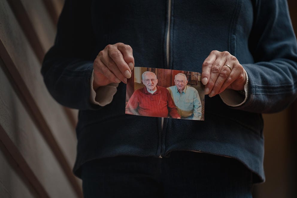 woman holding photo of two older men