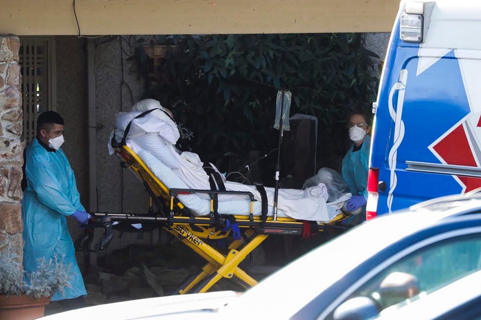 medical workers push a person in a bed