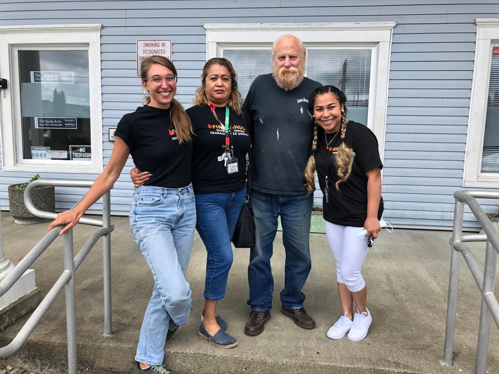 A group of four people standing in front of a building