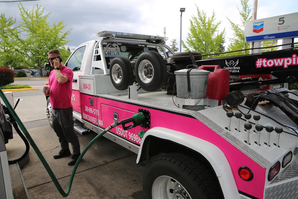 A man at a gas station with a truck