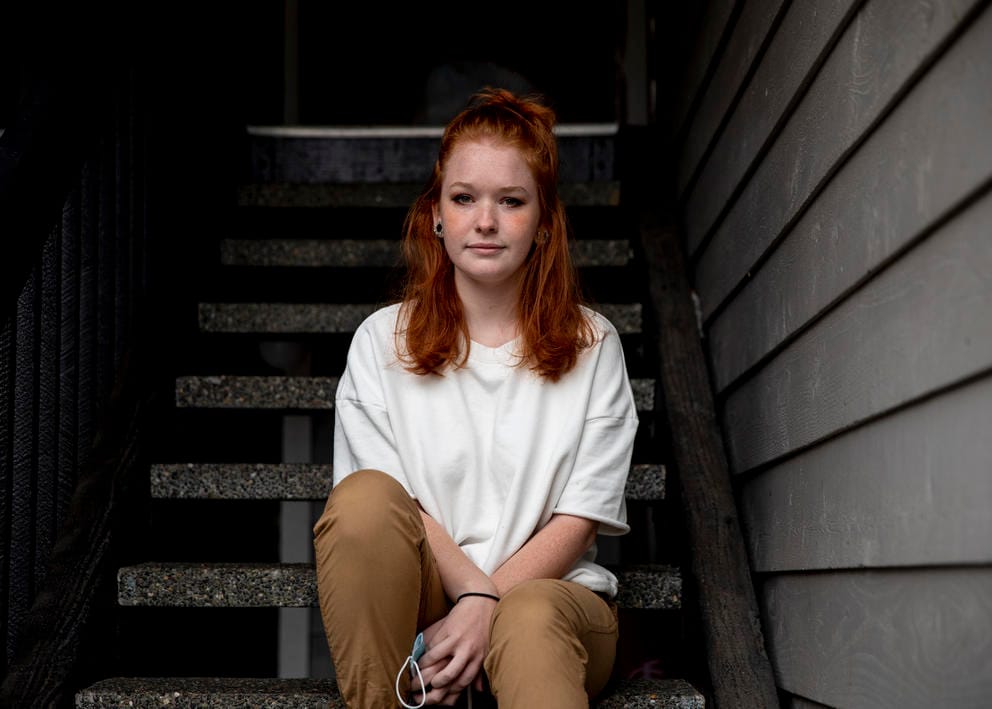 A woman sits outside on stairs