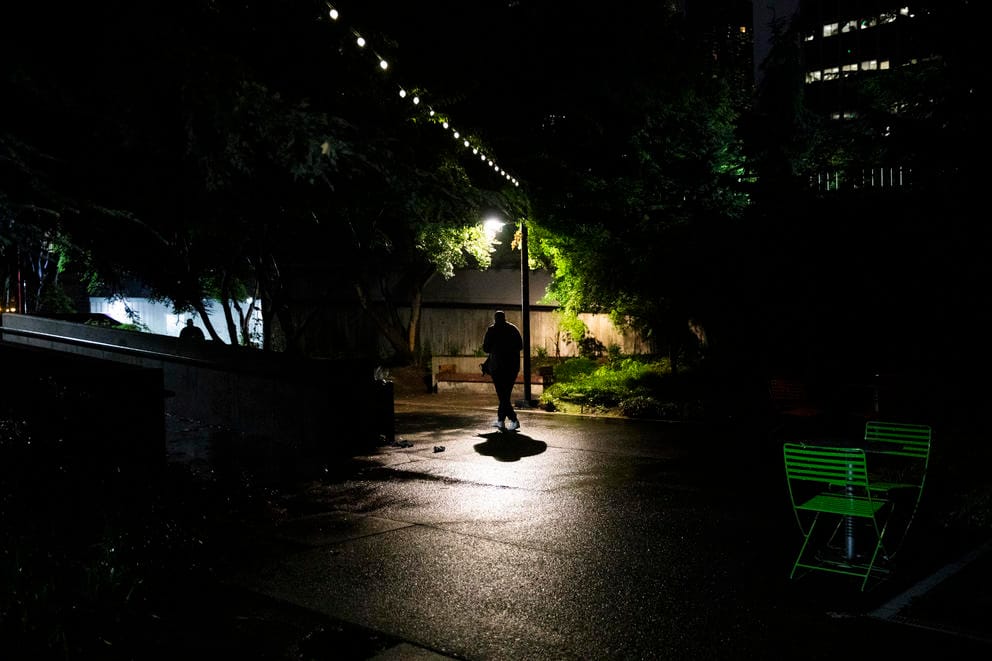 Dwight walks under street lamp at night