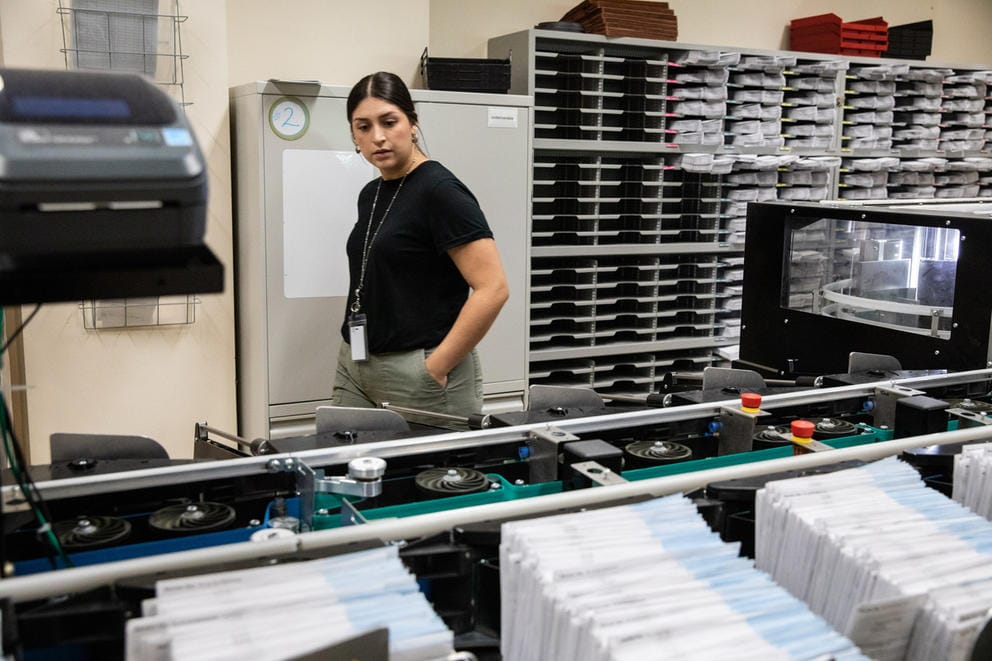 A woman observing ballot sorting