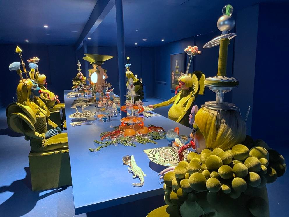 an elaborate dining room scene featuring humanoid aliens in outlandish costumes