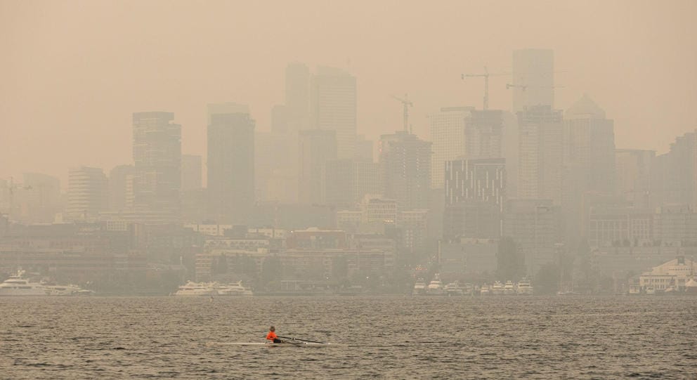 A kayaker on the water amid wildfire smoke