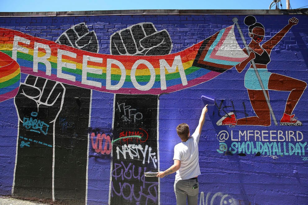 Colton Kenyon touches up a mural
