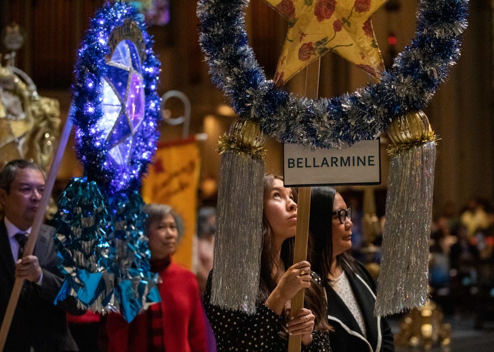 parishioners hold paroles during a processional