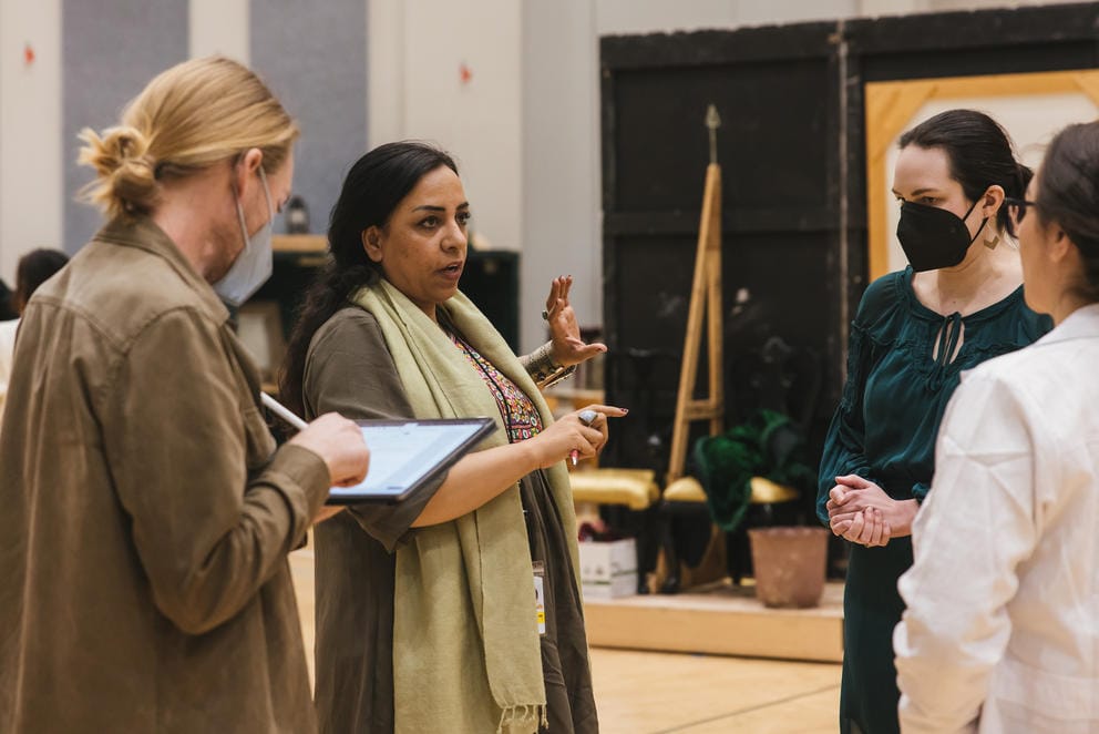 a photograph of several people talking backstage