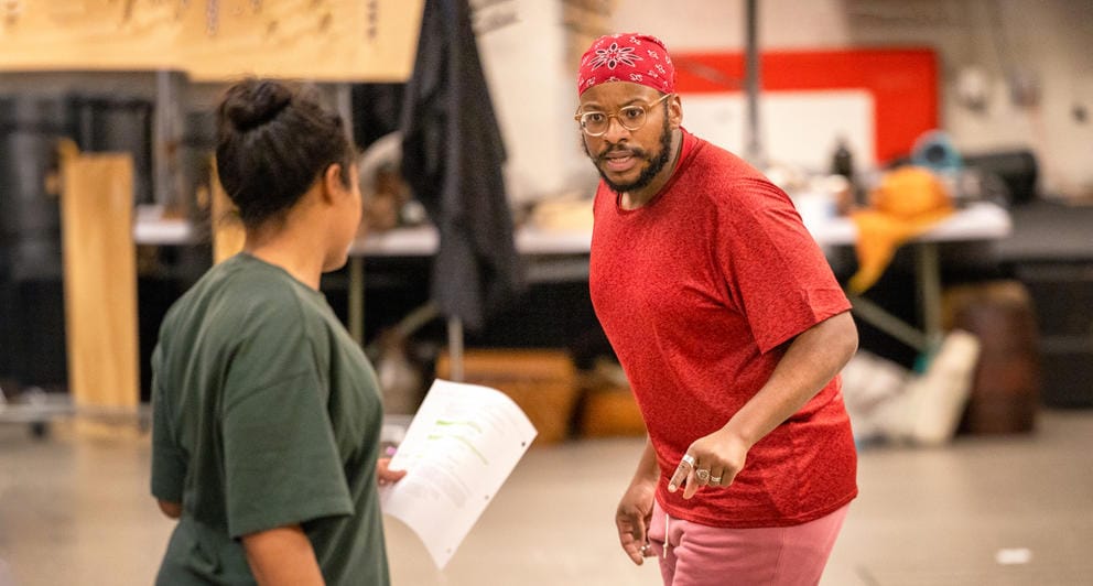 photo of a backstage rehearsal where a man and woman appear to be facing off