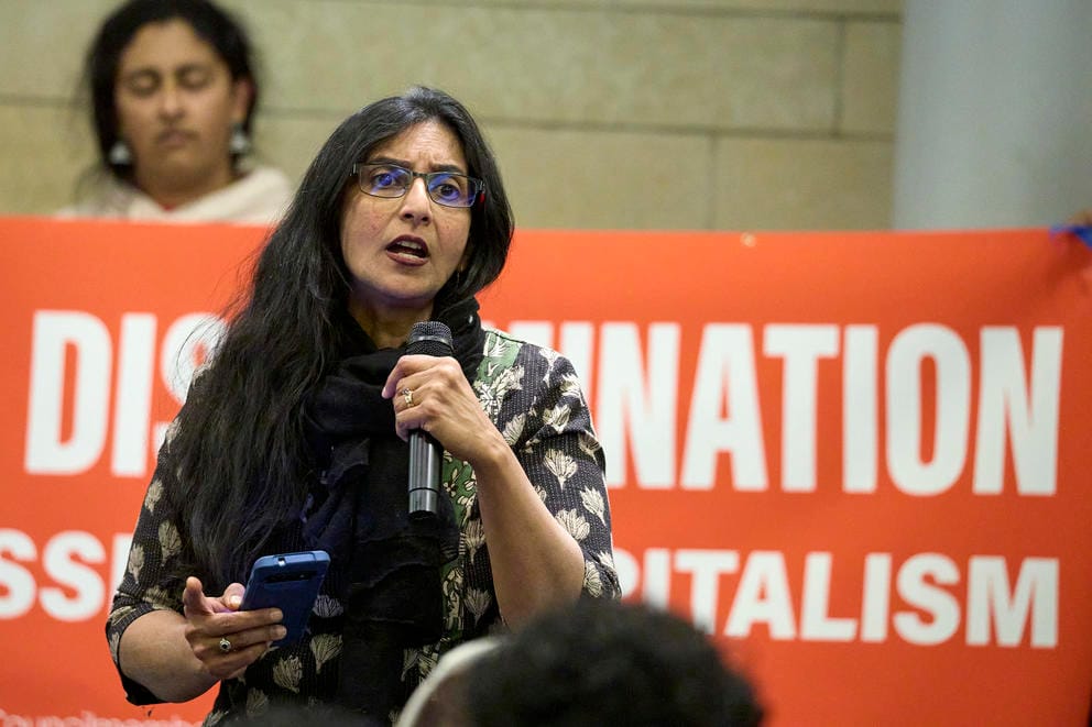 Seattle Council Member Kshama Sawant speaks into microphone