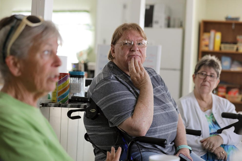 Three women sit and talk at a table