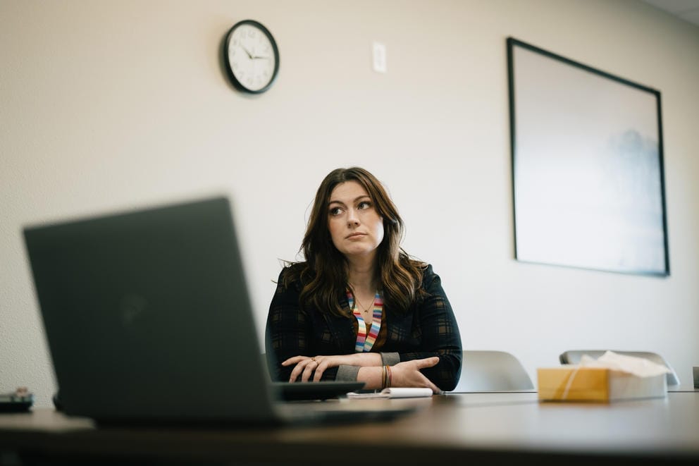 Megan Fultz sits at a desk with a laptop open in front of her.