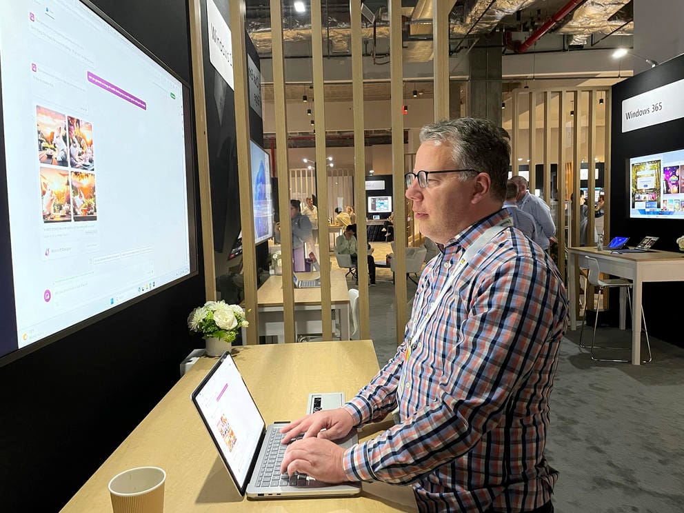 A person operates a computer that is displaying information on a large screen.