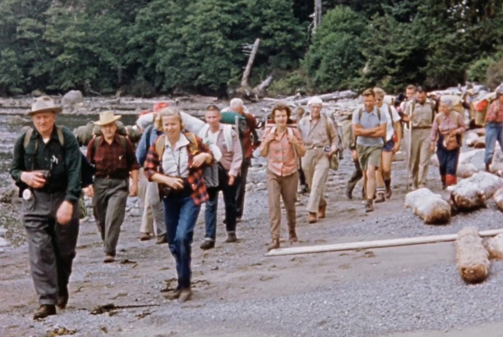 Justice Douglas leads a group of hikers on a beach