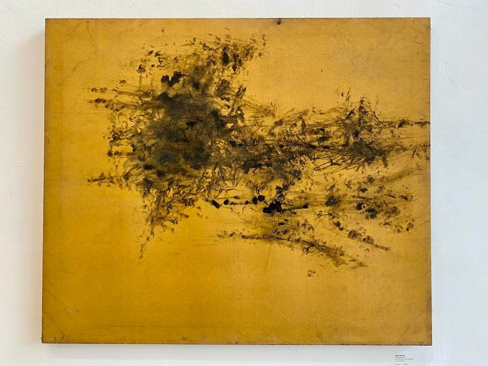 abstract drawing of black markings on golden canvas