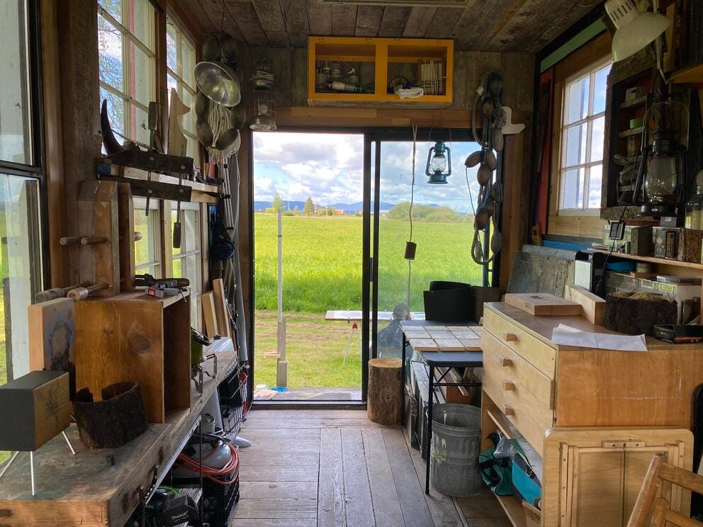 photo taken from inside a narrow studio with views out to bright green fields