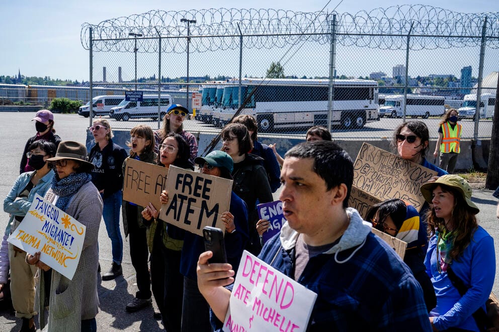 Demonstrators stand outside the Tacoma detention center